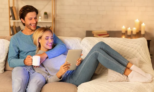 Millennial pareja usando tableta viendo película relajante en casa —  Fotos de Stock