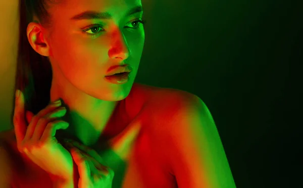 Sexy woman posing in neon green and orange lights — Stock Photo, Image