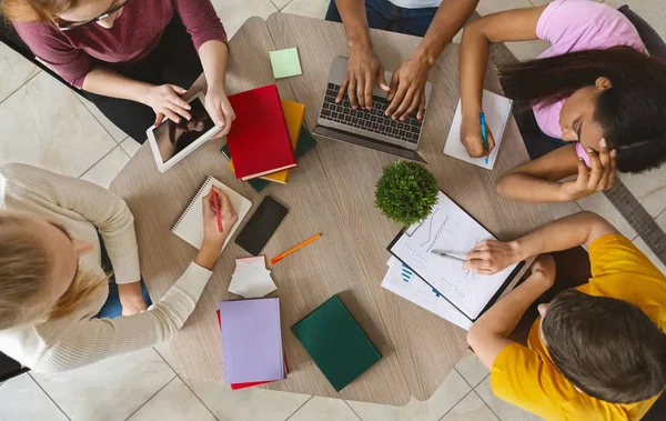 Groep internationale studenten zittend aan tafel, bovenaanzicht — Stockfoto