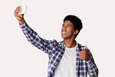 Mutlu adam selfie yapıyor ve başparmağını yukarı yaslar