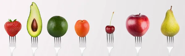 Collage de frutas y verduras por separado en tenedores en gris —  Fotos de Stock