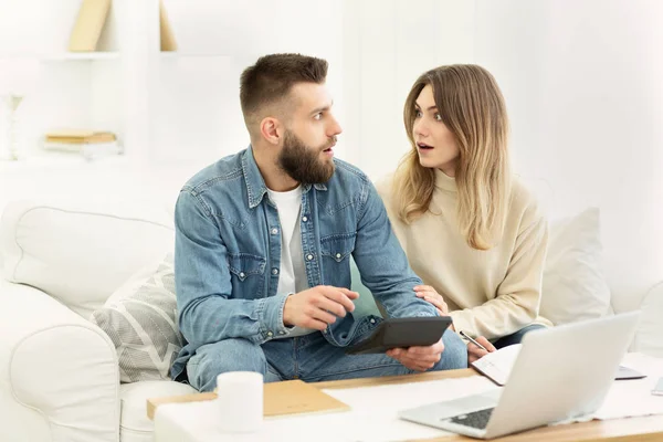 Shocked couple making financial revision at home — Stock Photo, Image