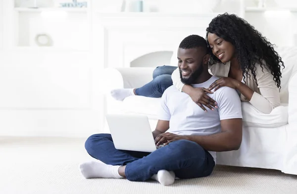 Woman embracing her boyfriend while they working on laptop together — Stock Photo, Image