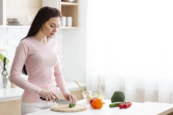 Young woman preparing fresh salad at kitchen — Stock Photo, Image
