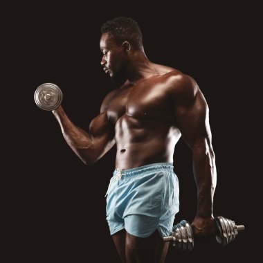 Siyah vücut geliştirmeci portresi tek kol dumbbell curl yapıyor