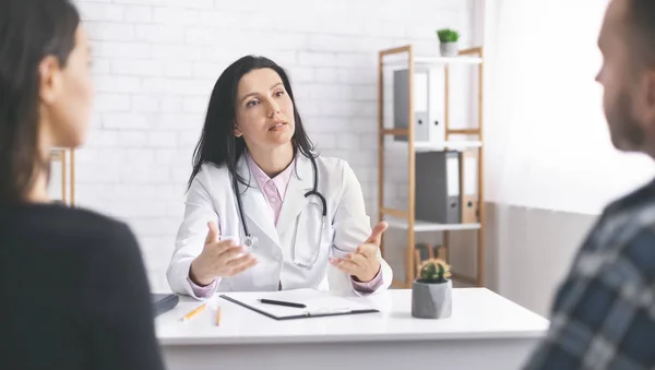 Médico explicando los síntomas a los pacientes durante la consulta —  Fotos de Stock