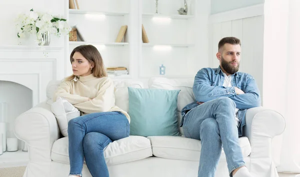 Young couple sitting on different sides of couch after quarrel — Stock Photo, Image