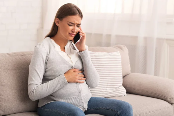 W ciąży dziewczyna rozmowa na Cellphone cierpienie z ból w Dom — Zdjęcie stockowe