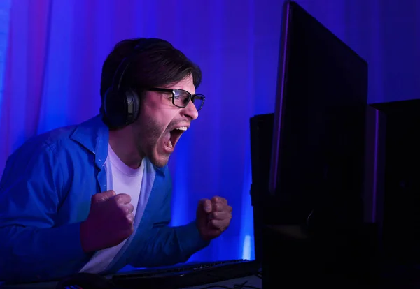 Concepto de juego. Hombre feliz en gafas celebrando la victoria en el juego —  Fotos de Stock