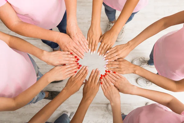 Women in Pink pólók tartja Hands in kör beltéri, Top-View — Stock Fotó