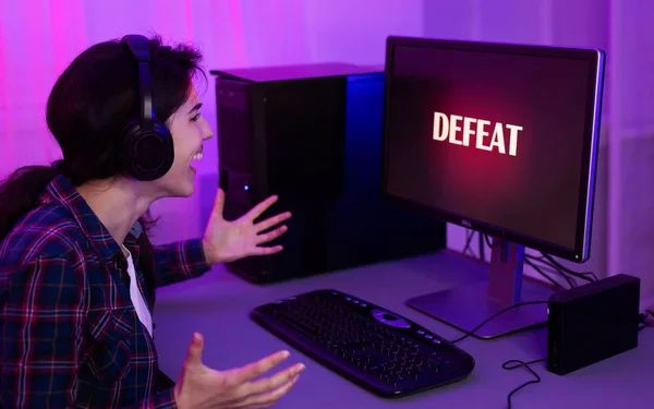 Злая девушка геймер, играющая в онлайн игры на компьютере — стоковое фото