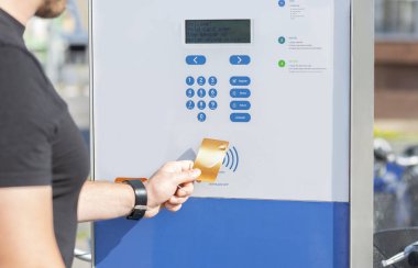 Adam kredi kartı ile bisiklet için ödeme, modern temassız sistemi kullanarak