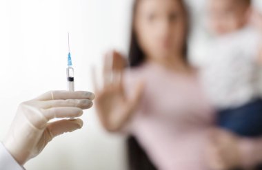 Anne bebek tutan ve şırınga ile doktor reddeden