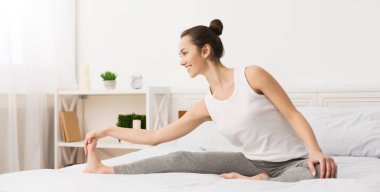 Fit kadın sabah erken yatağında bacaklarını germe