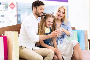 Alışveriş Merkezi'nde Bankta Oturan Akıllı Telefon Kullanan Aile