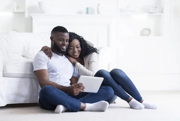 Afrikanisches Paar nutzt gemeinsam digitales Tablet während es zu Hause sitzt — Stockfoto