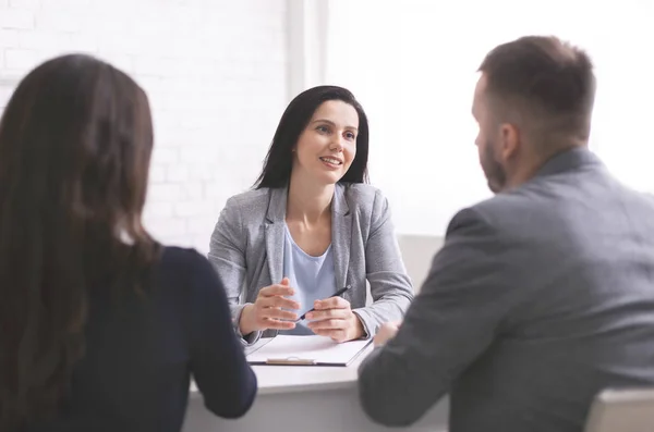 Professionele vrouw praat met jong stel op persoonlijke vergadering — Stockfoto