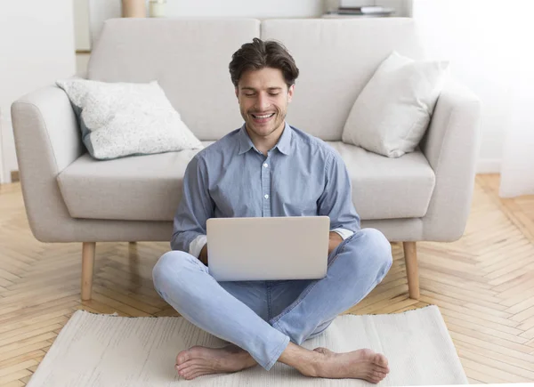 Udane Freelancer pracy na laptop siedzi na podłodze w domu — Zdjęcie stockowe