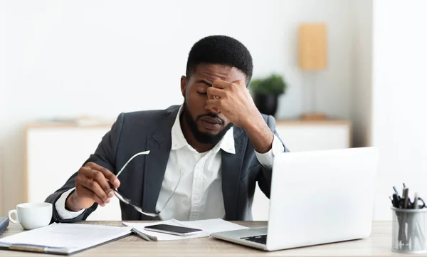 Overwerkte zakenman zittend op werkplek na een harde dag in kantoor — Stockfoto