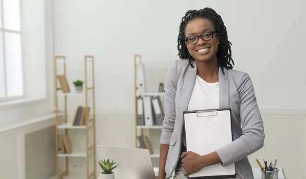 Business meisje Holding map glimlachend op camera in Office — Stockfoto