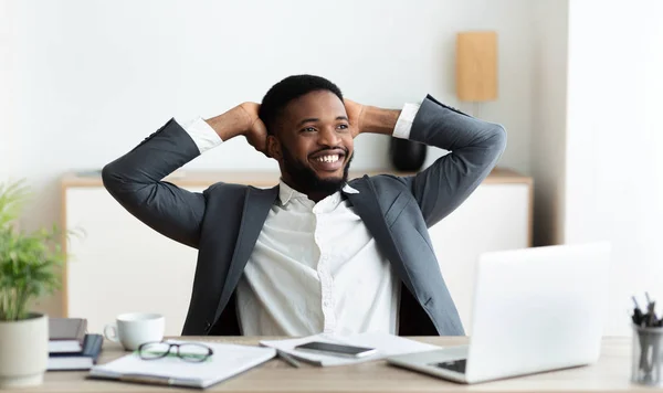 Negro hombre de negocios relajarse en el lugar de trabajo, recostado en la silla —  Fotos de Stock