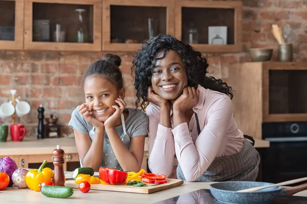 Mamá y su hija posando en la cámara mientras cocinan — Foto de Stock