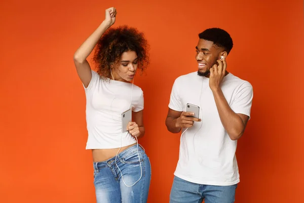 Pasangan Amerika yang bahagia mendengarkan musik online pada aplikasi seluler — Stok Foto