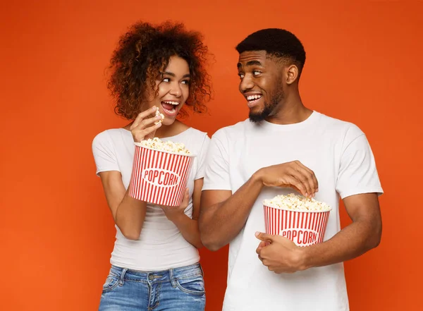 Hombre y mujer africanos positivos comiendo palomitas de maíz —  Fotos de Stock