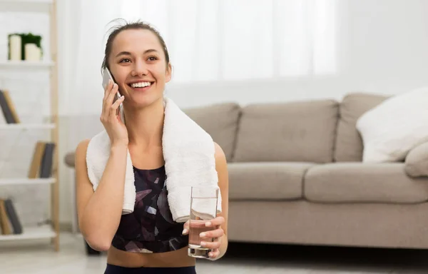 Chica en forma hablando por teléfono después de hacer ejercicio en casa — Foto de Stock