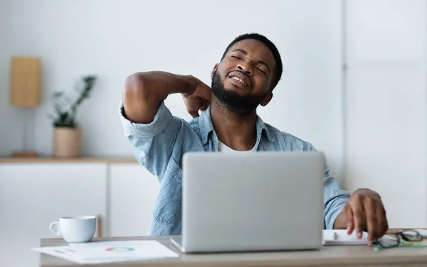 Hombre de negocios negro que sufre de dolor de cuello agudo después de un largo día de trabajo —  Fotos de Stock