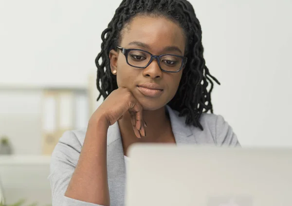 Chica de negocios afroamericana usando la computadora portátil sentada en el lugar de trabajo — Foto de Stock