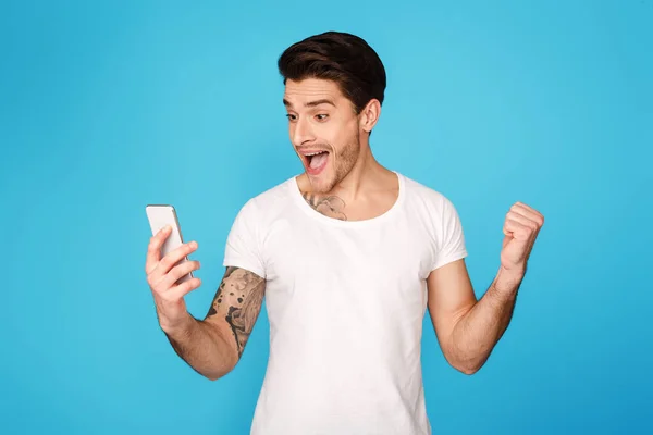 Homem feliz olhando para o celular e celebrando a vitória — Fotografia de Stock