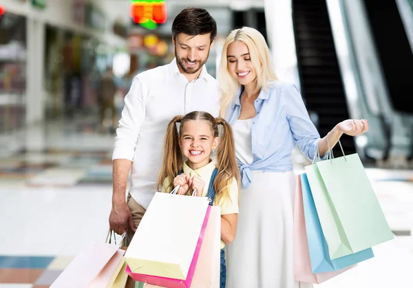 Pais felizes e filha em pé no shopping — Fotografia de Stock