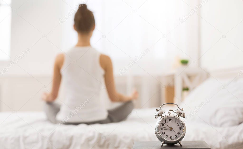 Early awakening. Woman practicing yoga in the morning