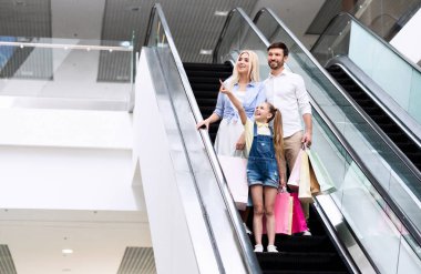 Hipermarkette Yürüyen Merdivende Duran Ebeveynlere Bir Şey Gösteren Kız