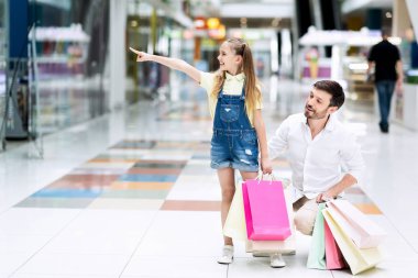 Alışveriş merkezinde babası ile alışveriş sırasında kız işaret parmak