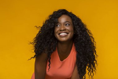 Geniş bir gülümseme ile heyecanlı Afrikalı kadın kenara bakıyor