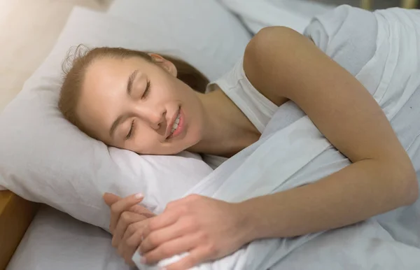 Gyönyörű fiatal nő alszik kényelmesen az ágyban — Stock Fotó