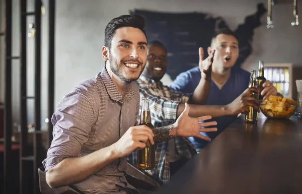 Futbolistas viendo partido en bar deportivo, bebiendo cerveza — Foto de Stock