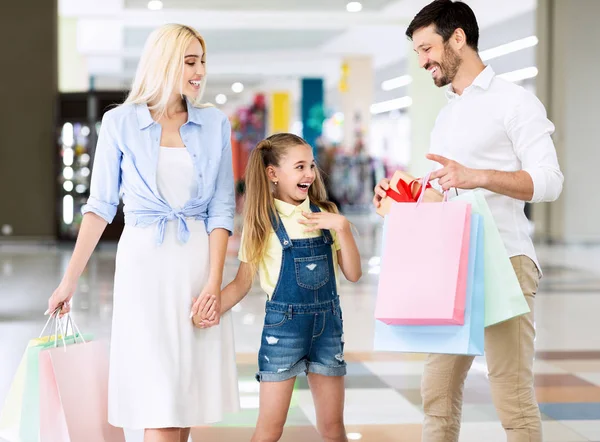 Pais dando a filha um presente durante as compras no shopping — Fotografia de Stock