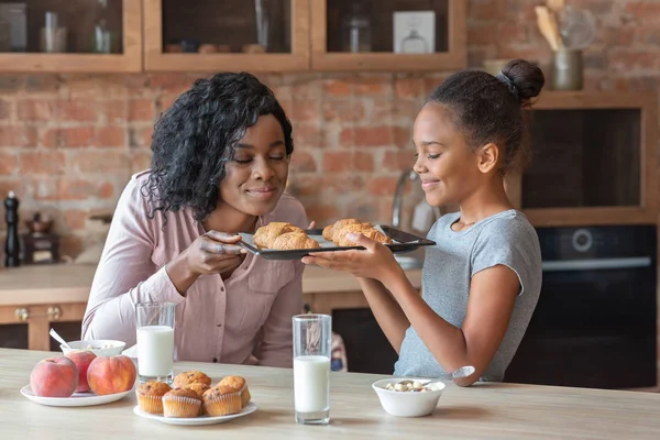 Chica feliz mostrando bandeja con croissants recién horneados — Foto de Stock