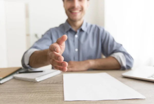 Sonriente hombre estirando la mano para el apretón de manos sentado en el lugar de trabajo, recortado —  Fotos de Stock