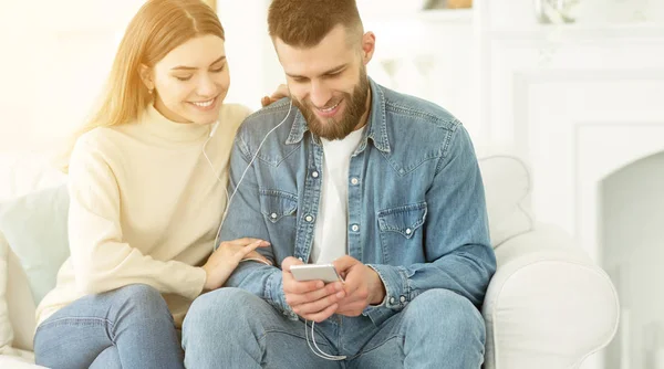 Pareja joven escuchando música en el teléfono juntos —  Fotos de Stock