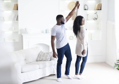 Romantik afro-amerikan çift evde dans, el ele tutuşarak
