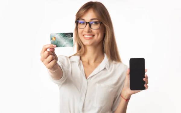 Lächelnde Geschäftsfrau zeigt Smartphone und Kreditkarte, weißer Hintergrund — Stockfoto