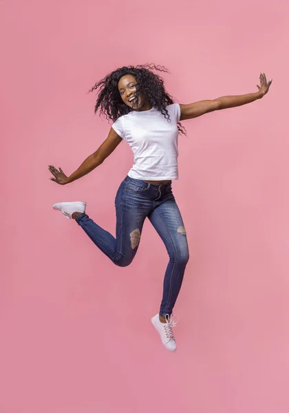 Stunning young girl jumping over pink background — Stock Photo, Image
