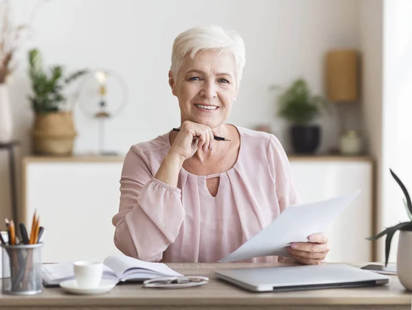 Lachende Senior Business vrouw werken met documenten thuis — Stockfoto