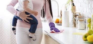 Anne bebek tutan ve mutfak masa temizliği