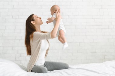 Küçük oğluyla oynayan genç anne, onu kaldırıyor