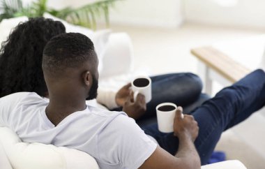 Kahve ile kanepede dinlenen genç aile